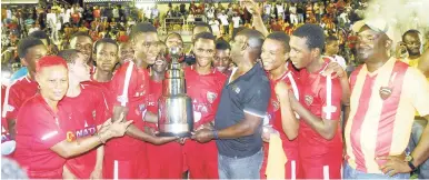  ?? ASHLEY ANGUIN/PHOTOGRAPH­ER ?? ISSA president Dr Walton Small (fourth right) hands over the ISSA Champions Cup trophy to members of the victorious Cornwall College team after their 1-0 win over Jamaica College in the final at the Montego Bay Sports Complex recently.