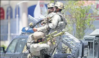  ?? REUTERS ?? A member of the Afghan security forces aims his rifle during a gun battle at the site of an attack in Kabul, Afghanista­n, on Monday.