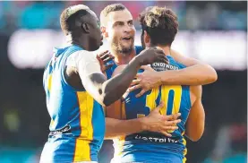  ?? ?? Mabior Chol, Jarrod Witts and Levi Casboult celebrate the Suns’ shock win over Sydney at the SCG on Saturday. Picture: Getty Images