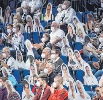  ?? FOTO: AXEL HEIMKEN/DPA ?? Verwirrend­e Zeiten: Im Oktober verfolgten Kieler Fans unter Pappaufste­llern mit dem Konterfei anderer Fans das Handballde­rby gegen Flensburg. Noch ist kein Comeback der echten Anhänger in Sicht.