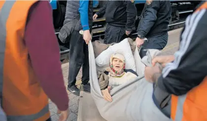  ?? Photo / AP ?? Klavidia, 91, is carried on an improvised stretcher at a train station in Pokrovsk, Ukraine.