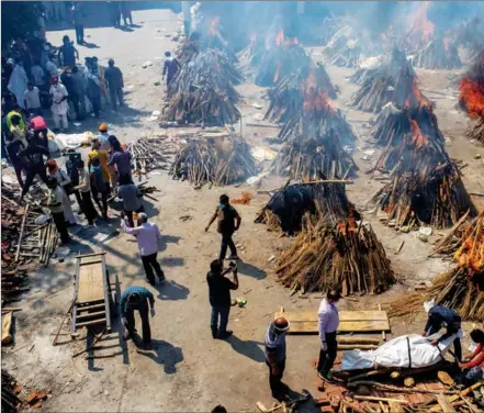  ?? ALTAF QADRI / ASSOCIATED PRESS ?? Multiple funeral pyres of victims of COVID-19 burn in an area converted into a crematoriu­m for mass cremations s in New Delhi, on April 24.