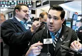  ?? RICHARD DREW/AP ?? Joseph Lawler, right, works with fellow traders on the floor of the New York Stock Exchange on Tuesday.