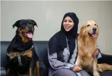  ?? Victor Besa for The National ?? Sara Al Zaki with Dusty, a rottweiler, and Jess, a golden retriever. She finds homes for banned breeds
