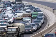  ?? (AP Photo/ Hassan Ammar) ?? A general view of a petrol station on the main highway that link the Capital Beirut to south Lebanon as a man holds a gallon of fuel, right, while cars come from every direction to try and fill their tanks with gasoline, in the coastal town of Jiyeh, south of Beirut, Lebanon, Friday, Sept. 3, 2021. Lebanon is mired in a devastatin­g economic and financial crisis, the worst in its modern history. A result of this has been crippling power cuts and severe shortages in gasoline and diesel that have been blamed on smuggling, hoarding and the cash-strapped government’s inability to secure deliveries of oil products.