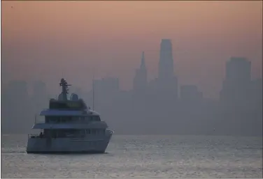  ?? ERIC RISBERG — THE ASSOCIATED PRESS ?? Smoke from wildfires blankets the San Francisco skyline Monday in this view from Sausalito. Officials said the air quality in the Bay Area could be at its dirtiest by midday today. Public buildings with filtered air can provide relief for those who struggle to breathe.
