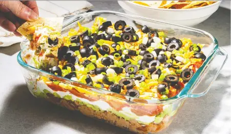  ?? REY LOPEZ/FOR THE WASHINGTON POST ?? It's simple to modify a standard seven-layer dip with lettuce, pickled jalapeños, corn kernels or ground meat.