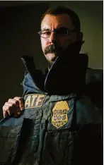  ?? Jon Shapley / Houston Chronicle ?? Special Agent Eric Evers of the Houston field office displays the body armor vest he wore during the raid on the Branch Davidian compound outside Waco in 1993.