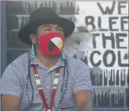  ?? RICK BOWMER - STAFF, AP ?? Native American advocate Carl Moore sits near the phrase “We Bleed These Colors” along a walkway which leads from the Bountiful High School parking lot up to the football field Tuesday, July 28, 2020, in Bountiful, Utah.