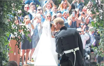  ??  ?? The kiss that everyone was waiting for between the smitten couple on the steps of St George’s Chapel