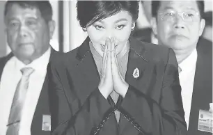  ?? — Gambar Reuters ?? BELA DIRI: Yingluck Shinawatra menekup tangan tanda hormat setibanya di Parlimen sebelum mesyuarat Dewan Undangan Negara di Bangkok semalam.