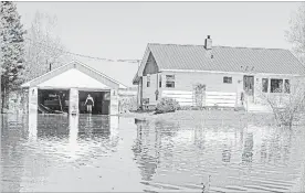  ?? JAMES WEST THE CANADIAN PRESS ?? Rick Banks walks past his garage while cleaning up debris from his property located along route 105 in Maugervill­e, N.B, Wednesday.