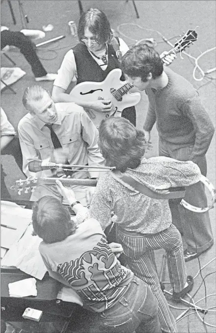  ?? Tony Bramwell Copyright Apple Corps Ltd. ?? PRODUCER George Martin, in the center wearing a tie, consults with the Beatles during a recording session circa 1968.