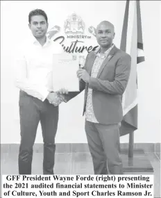  ?? ?? GFF President Wayne Forde (right) presenting the 2021 audited financial statements to Minister of Culture, Youth and Sport Charles Ramson Jr.