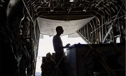  ?? Victor J. Blue / The Washington Post ?? A flight technician prepares cargo in a C-130 aircraft at Bagram Airfield in Bagram, Afghanista­n. The last American troops left this airport this week.