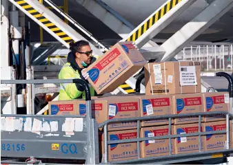  ??  ?? Le 21 mars 2020, à l’aéroport internatio­nal d’Athènes, le personnel décharge l’aide médicale de la Chine à la Grèce d’un avion d’Air China.