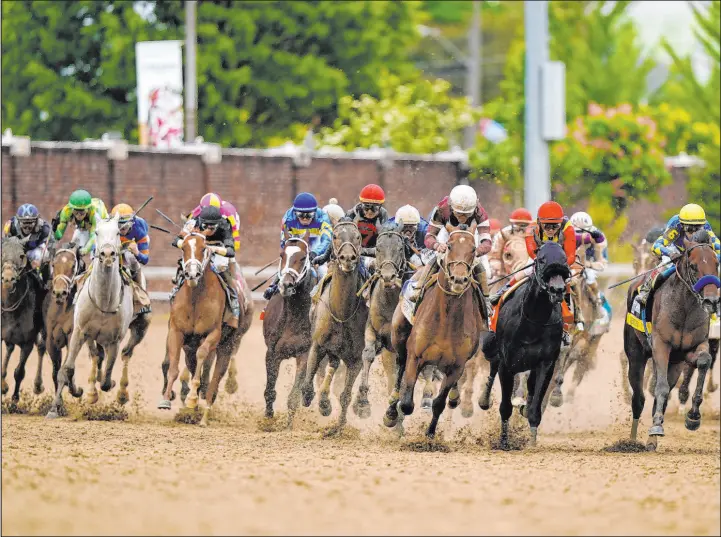  ?? Brynn Anderson The Associated Press ?? Horses round the fourth turn Saturday during the 148th running of the Kentucky Derby at Churchill Downs in Louisville, Ky.