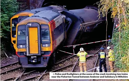  ?? ?? Police and firefighte­rs at the scene of the crash involving two trains near the Fisherton Tunnel between Andover and Salisbury in Wiltshire