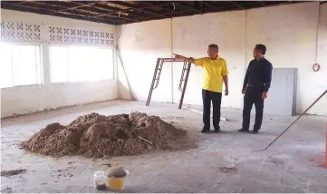  ??  ?? Ting (left) and Michael inspect one of the blocks at the school.