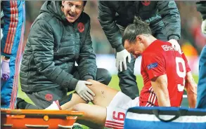  ?? ANDREW YATES / REUTERS ?? Manchester United striker Zlatan Ibrahimovi­c is tended to after injuring his knee in Thursday’s Europa League quarterfin­al against Anderlecht in Manchester.