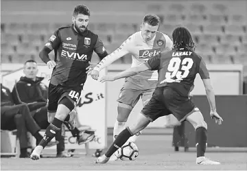  ??  ?? Napoli’s Polish midfielder Piotr Zielinski (centre) fights for the ball with Genoa’s Uruguayan midfielder Diego Laxalt (right) and Genoa’s Portuguese midfielder Miguel Veloso during the Italian Serie A football match SSC Napoli vs Genoa CFC at the San...