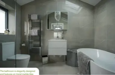  ??  ?? The bathroom is elegantly designed and features on-trend marble tiles