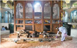  ?? ASIF HASSAN/AGENCE FRANCE-PRESSE VIA GETTY IMAGES ?? A security official collects evidence after a bomb attack hit the 13th century Muslim Sufi shrine of Lal Shahbaz Qalandar in the town of Sehwan in Sindh province, Pakistan.