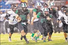  ?? [BRYAN TERRY/ THE OKLAHOMAN] ?? Jones running back Korbin Cox, left, picks up some yards during Thursday night's 61-0 district victory over Henryetta. Cox scored five touchdowns in the win.