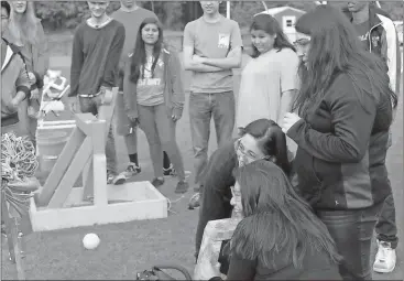  ?? Spencer Lahr / Rome News-Tribune ?? Yazmine Perez (clockwise from front), Paullette Delgado and Ruby Martinez watch as their catapult’s slingshot, which was made of rubber bands, fails to launch a tennis ball Friday on the Rome High practice field.