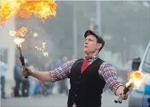  ?? PETER LEE WATERLOO REGION RECORD ?? Kobbler Jay the Eccentric Juggler (Jason Henderson of Niagara Falls) breathes fire as he juggles his flaming batons, entertaini­ng spectators gathered along the parade route.