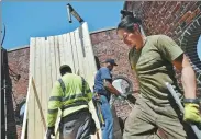  ?? HECTOR RETAMAL / AGENCE FRANCE-PRESSE ?? Workers install a water tank on a building on Lexington Ave on May 9 in New York.