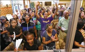  ?? CURTIS COMPTON/CCOMPTON@AJC.COM ?? An overflow crowd reacts from the lobby outside the Buford City Schools meeting chambers at a board meeting Monday. Several hundred people attended the meeting. The temperatur­e was high in the crowded chambers.