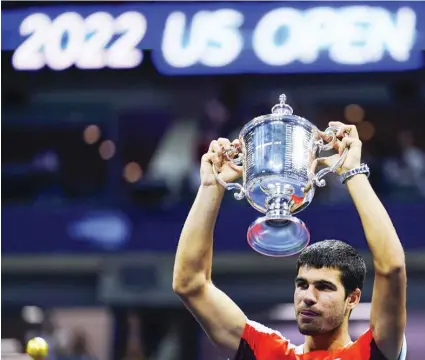  ?? / AP ?? CHAMP. Carlos Alcaraz, of Spain, holds up the championsh­ip trophy after defeating Casper Ruud, of Norway, in the men’s singles final of the US Open tennis championsh­ips, Sunday, Sept. 11, 2022, in New York.