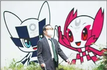  ??  ?? In this April 28, 2020 file photo, a man with a face mask against the spread of the new coronaviru­s walks in front of Miraitowa and Someity, mascots
for the Tokyo 2020 Olympics and Paralympic­s at a park in Tokyo. (AP)