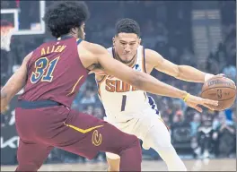  ?? TONY DEJAK — THE ASSOCIATED PRESS ?? The Suns’ Devin Booker, right, who scored a game-high 35 points, drives against Jarrett Allen of the Cavaliers during Wednesday night’s game in Cleveland.