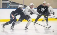  ?? JASON FRANSON THE CANADIAN PRESS ?? Connor McDavid, centre, and Caleb Jones battle for the puck during a scrimmage at the Oilers training camp last week.