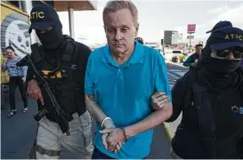  ?? Moises Castillo / Associated Press ?? Kentucky lawyer Eric Conn, who fled the country after pleading guilty to a $500 million fraud scheme, is escorted by Honduran SWAT agents.