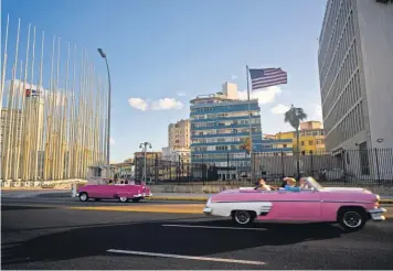  ?? RAMON ESPINOSA, AP ?? Tourists ride in classic American convertibl­es past the U. S. Embassy, right, in Havana.