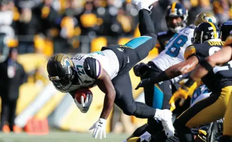  ?? KEVIN C. COX/GETTY IMAGES ?? Jaguars running back Leonard Fournette dives into the end zone for a touchdown against the Steelers on Sunday in Pittsburgh.