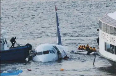  ?? AP PHOTO/ BEBETO MATTHEWS, FILE ?? In this 2009file photo, a diver, left, aboard an NYPD vessel prepares to rescue passengers that escaped from the Airbus 320US Airways aircraft that made an emergency landing in the Hudson River in New York in what came to be known as the “Miracle on the Hudson” because everyone survived.