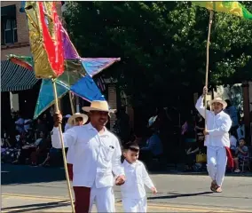  ?? RECORDER PHOTO BY ESTHER AVILA ?? From left, Director General Hugo Martinez holds the hand of Moises Sandoval as he dances with Luis Franco of Grupo Folklorico Tangu Yuu of Fresno during the CHMA Cinco de Mayo parade on Saturday in Portervill­e.