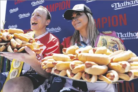  ?? JULIA NIKHINSON – STAFF, AP ?? JOEY CHESTNUT AND MIKI SUDO POSE WITH 63 AND 40 HOT DOGS, July hot dog eating contest in Coney Island on Monday in New York. respective­ly, after winning the Nathan’s Famous Fourth of