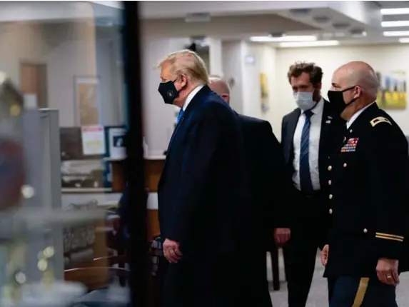  ?? (EPA) ?? The president wore a mask yesterday during a visit to a medical facility in Maryland