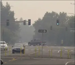  ?? SCOTT SONNER — THE ASSOCIATED PRESS ?? Smoke from wildfires in neighborin­g California blankets neighborho­od streets in suburban Sparks, Nev., just east of Reno, Monday. The Washoe County School District closed all schools including those in Reno, Sparks and parts of Lake Tahoe on Monday due to the hazardous air quality. The county health district urged the general public to “stay inside as much as possible” due to conditions expected to continue through Wednesday.