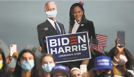  ?? Joe Raedle / Getty Images ?? Above: Cardboard cutouts of Joe Biden and Kamala Harris rise above a Miami rally Monday. The election proved that this will be a very difficult country for a Democratic president to govern. Below: Nancy Pelosi faces more struggles as House speaker.