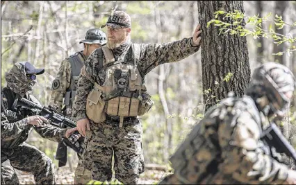  ?? LISA MARIE PANE PHOTOS / AP ?? Chris Hill looks on during training exercises in the woods of Jackson in April with the Georgia Security Force. Armed militias, still wary of perceived threats, foreign and domestic, say they aren’t ready to lay down their arms under President Donald...