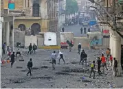  ?? (AFP) ?? People clash with security forces in Baghdad’s Al-Rasheed street near Al-Ahrar bridge on November 25