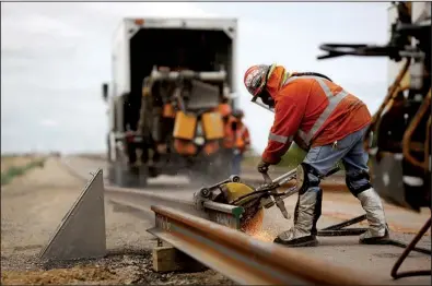  ?? Bloomberg News/LUKE SHARRETT ?? A worker links a new BNSF Railway rail in Alva, Okla., in 2015. BNSF is one of several railroads that are fighting an effort to make them responsibl­e for compliance with a biofuel rule.