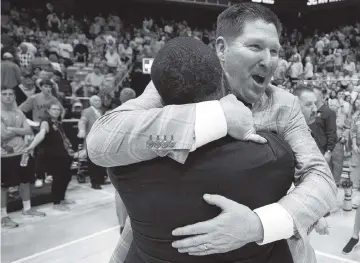  ?? ROBERT WILLETT The News & Observer ?? Clemson coach Brad Brownell embraces assistant coach Anthony Goins as they celebrate the Tigers’ first-ever win at North Carolina after Clemson escaped by beating the Tar Heels in overtime on Saturday.