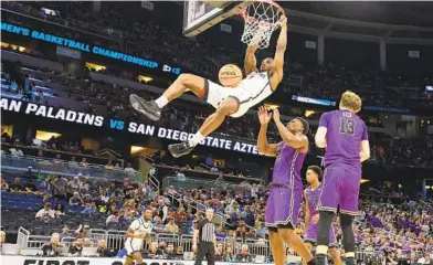  ?? K.C. ALFRED U-T ?? Aztecs’ Lamont Butler dunks over Furman’s Alex Williams during San Diego State’s second-round NCAA victory Saturday.